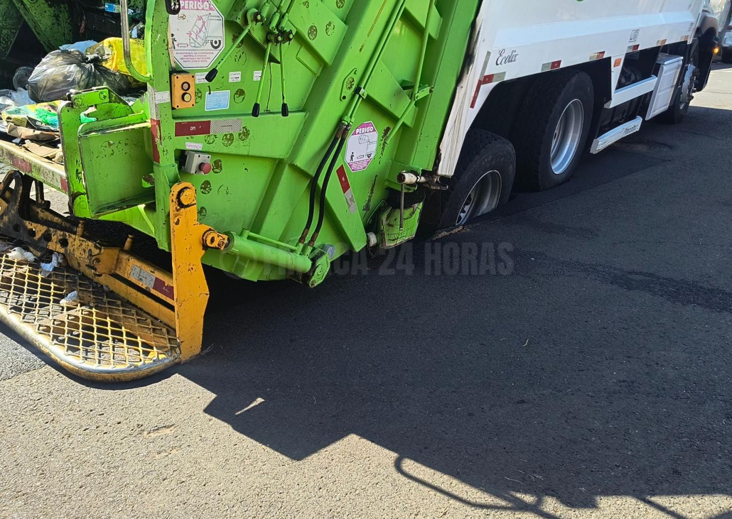 Asfalto cede e caminhão de lixo fica preso em buraco no Centro