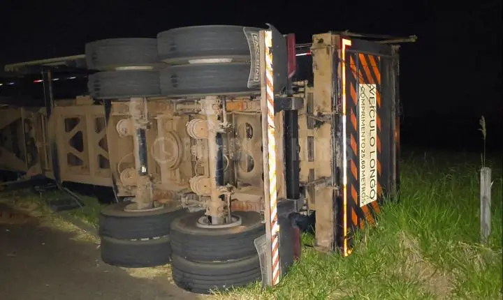 Asfalto cede, reboque tomba e carga cai em vegetação no Distrito Industrial